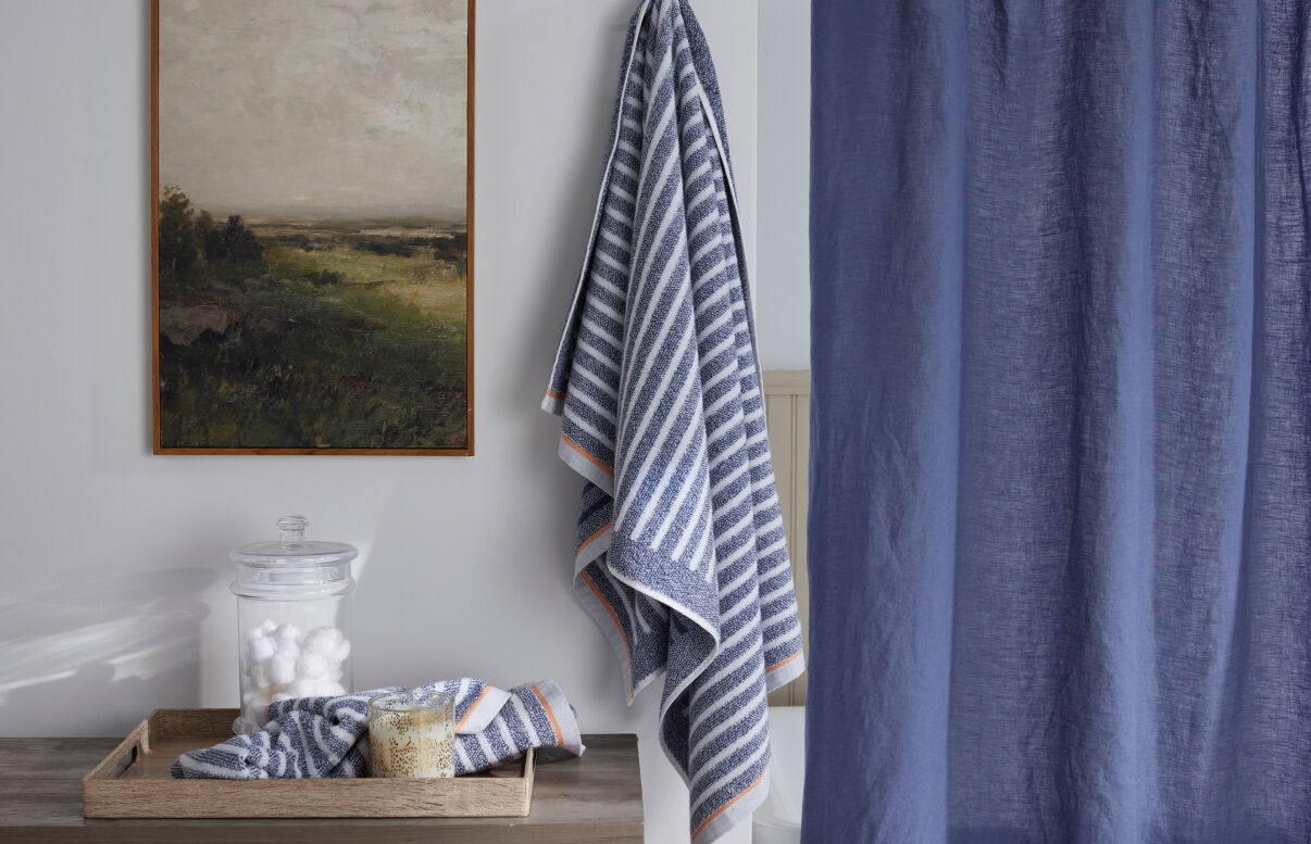 Image of a bathroom with blue striped towels and blue shower curtain