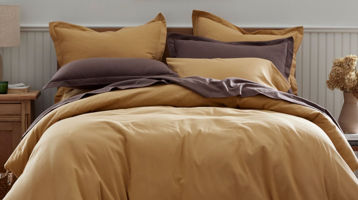 Image of bed made with gold duvet cover